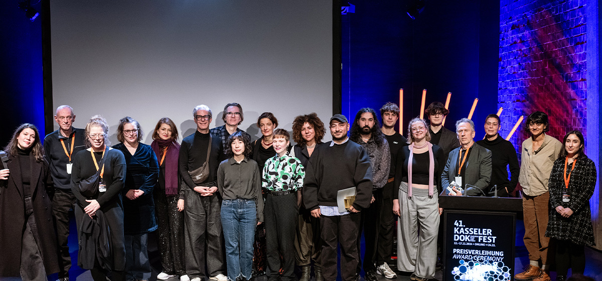 Gruppenfoto aller Jurys und drei Preisträger:innen beim Kasseler Dokfest 2024